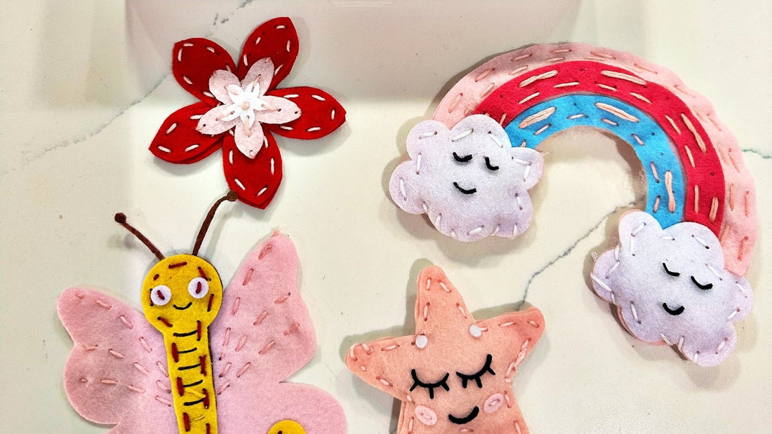 Finished felt projects from the Pinwheel Crafts Fairytale Sewing Kit: a flower, a rainbow with clouds, a butterfly and a star.