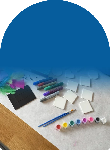 Tiles, paints, glitter glue, feathers, googly eyes, and magnets, all in one box
