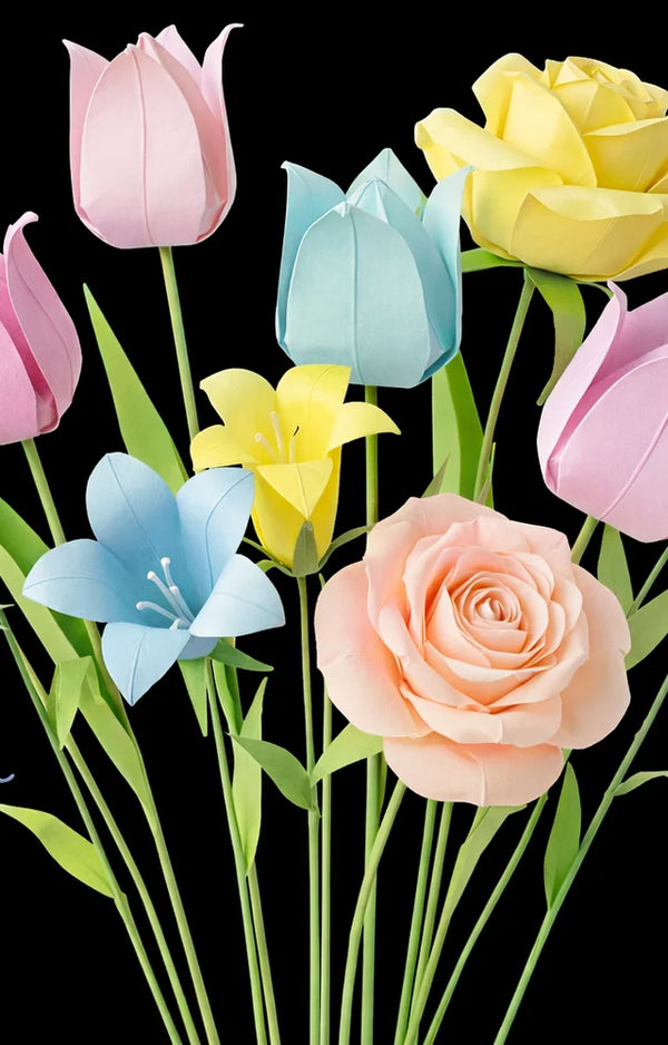 Pastel paper tulips, roses and lilies in pink, yellow, blue and peach on long stems against black