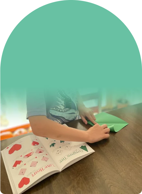 No screens, just paper, a book, and two busy hands
