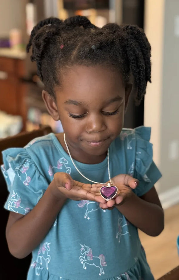 Girl holding a finished pendant in her hands