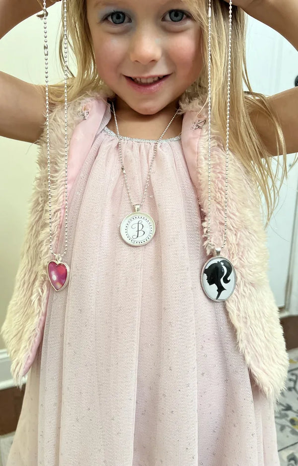 Girl wearing several pendant necklaces she made
