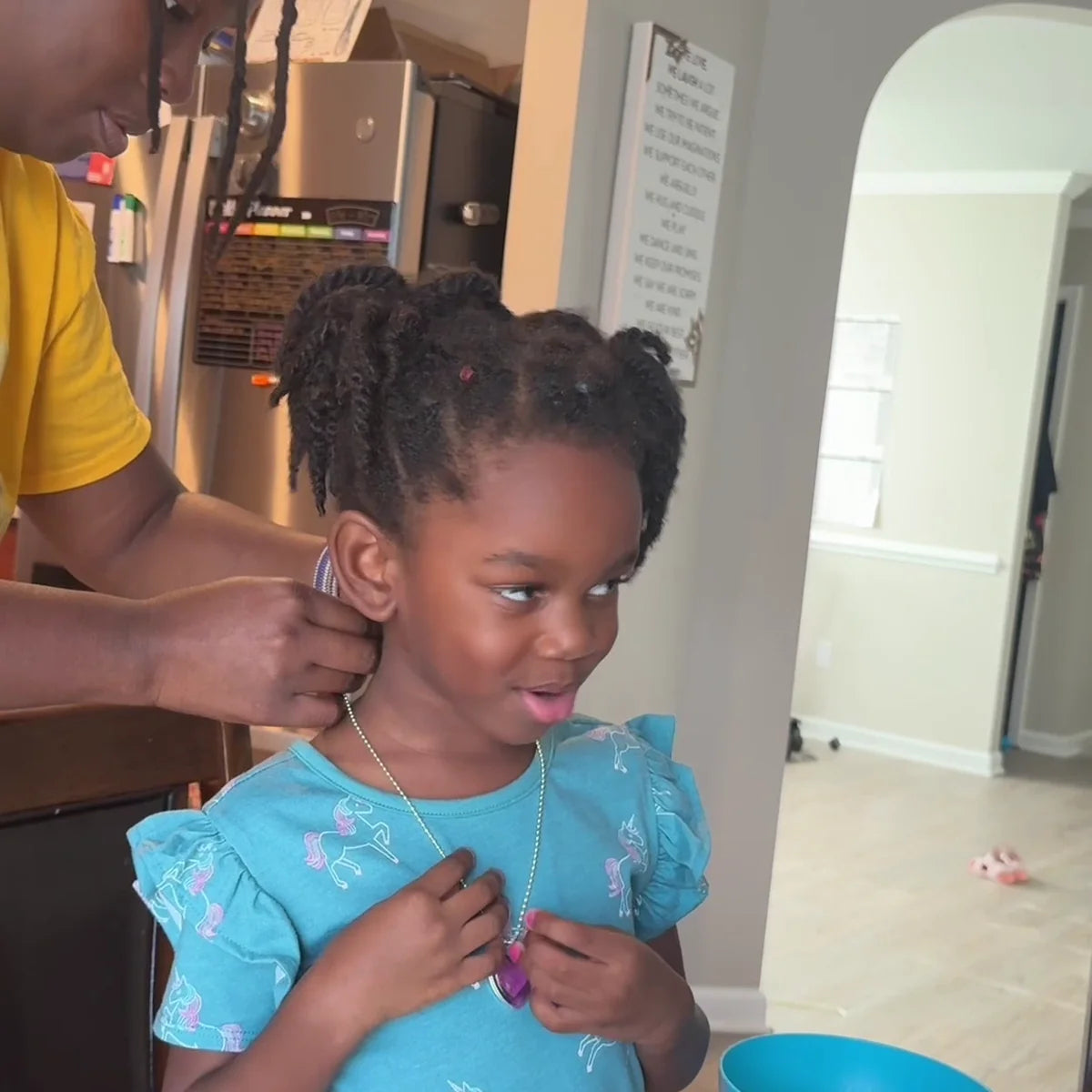 Mother fastening a handmade pendant necklace on her smiling daughter