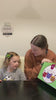 A mother and young daughter paint a pot red and add eyes and antennae to make a ladybug pot