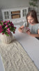 A girl opens the Paracord Bracelet Kit, then cord is woven into a pink bracelet worn on her wrist