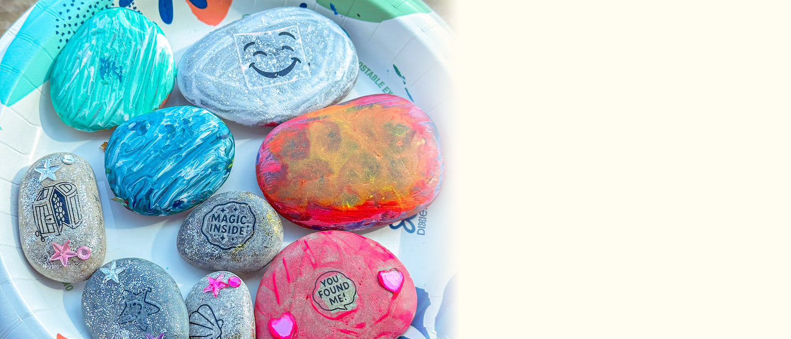 Colorful painted rocks on a white plate with a white background
