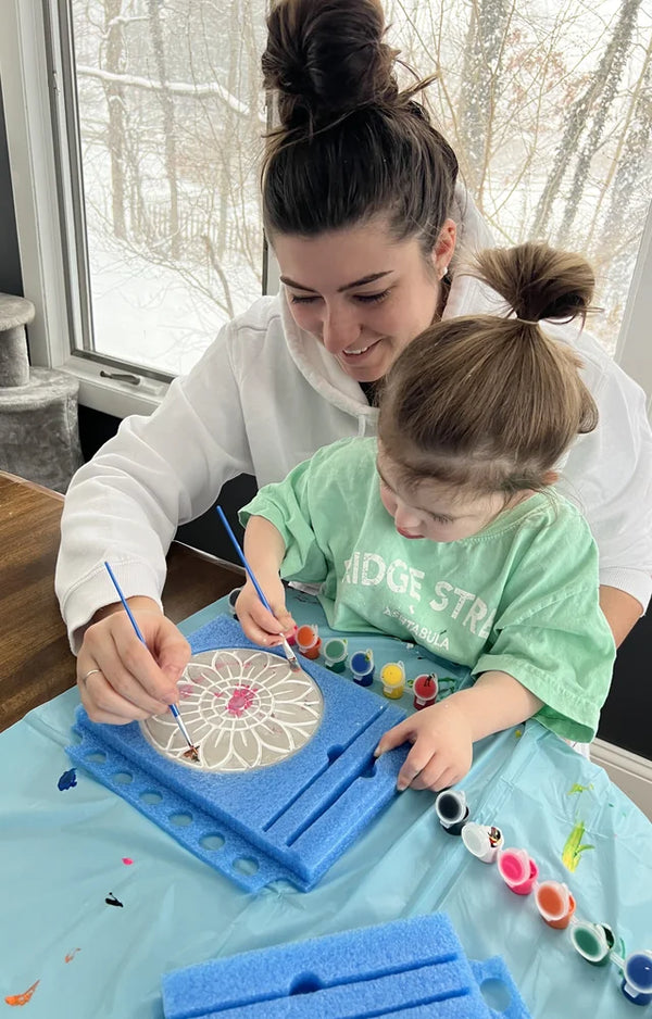 Mom and daughter painting the sunflower mosaic stepping stone together