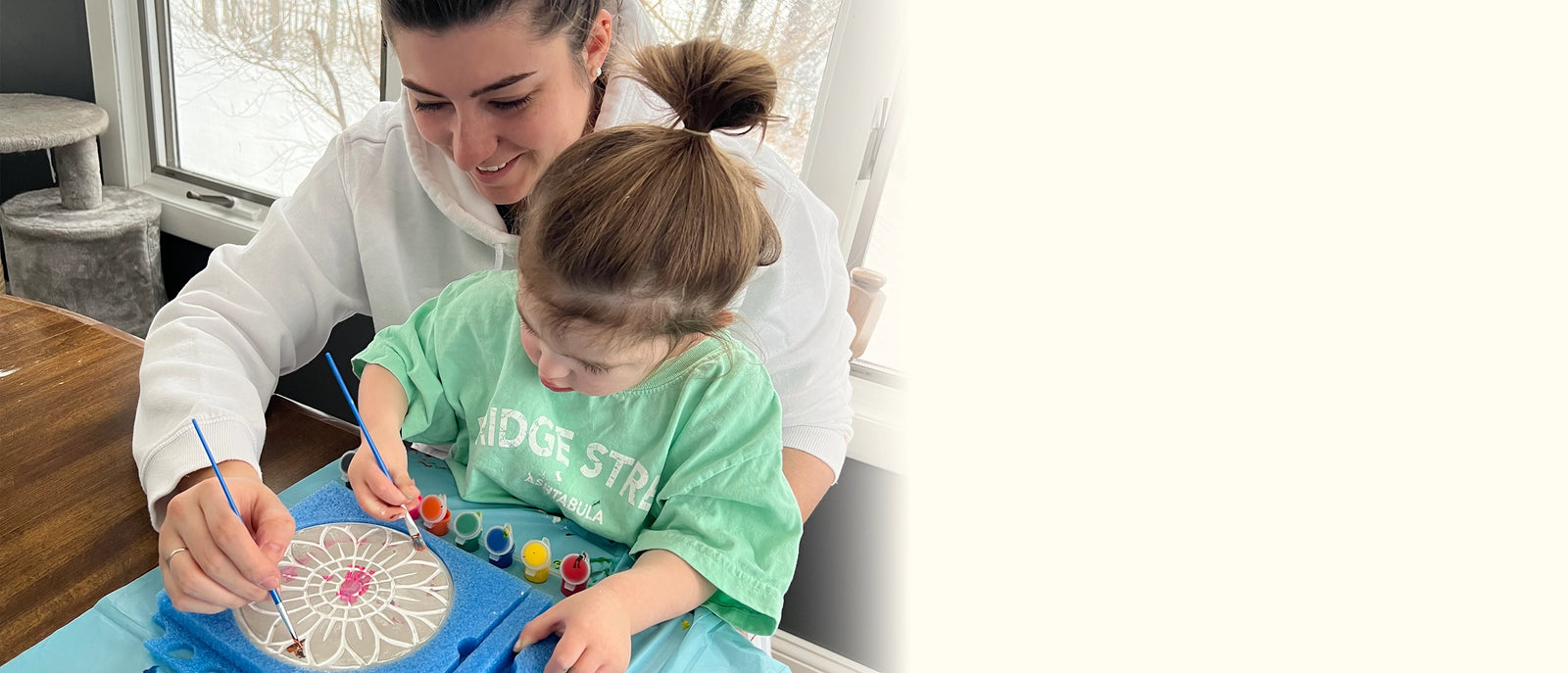 Woman and child engaged in a weather‑resistant stepping stone kit craft activity with paint
